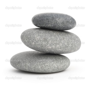 three pebbles stacked one onto each other, 3 stones over white background